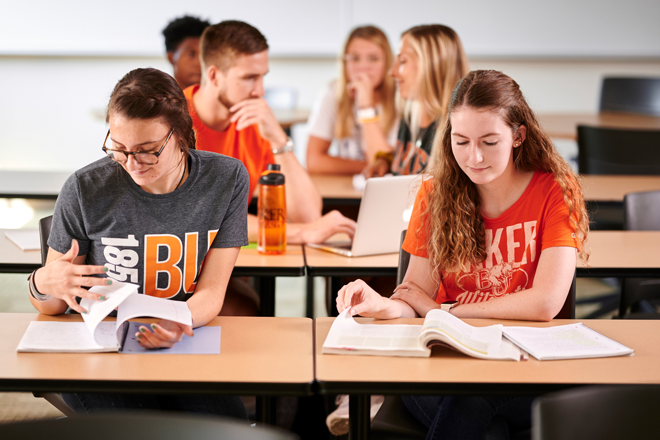 Students looking at books in a classroom